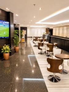 a conference room with tables and chairs and a tv at توارن للشقق المخدومة اقتصادي in Al Khobar
