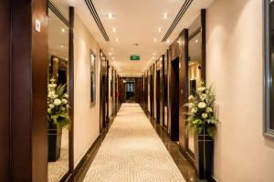 a corridor of a hotel hallway with flowers at توارن للشقق المخدومة اقتصادي in Al Khobar