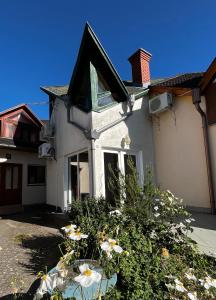 a white house with flowers in front of it at Sziget Apartman Fonyód in Fonyód