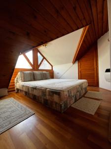 a bedroom with a large bed in a attic at Sziget Apartman Fonyód in Fonyód