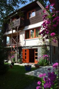 a house with a balcony and a yard with flowers at Casa Camelia in Sovata
