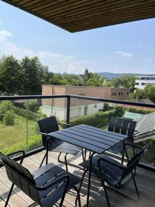 a table and chairs on a balcony with a view at REGENTova SUITES Ljubljana in Ljubljana