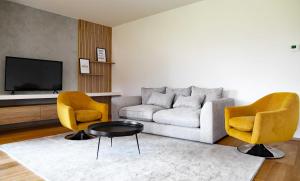 a living room with a couch and two chairs at REGENTova SUITES Ljubljana in Ljubljana