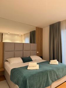 a bedroom with a large bed with two towels on it at REGENTova SUITES Ljubljana in Ljubljana