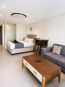 a living room with a bed and a couch at Ocean Dunes Bachelor Apartments in Umhlanga +69 photos