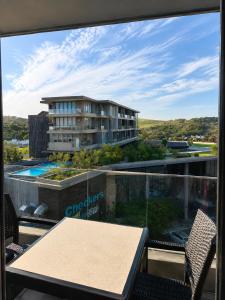 a balcony with a table and chairs and a building at Ocean Dunes Bachelor Apartments in Umhlanga