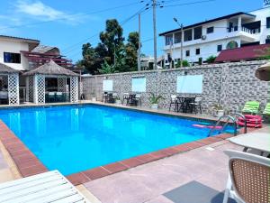 a swimming pool with blue water in front of a building at Le Ranch Hôtel San-Pedro in San-Pédro