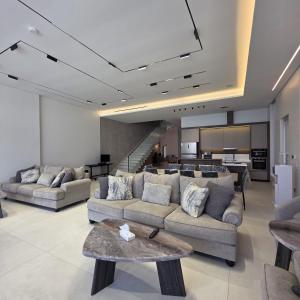 a living room with two couches and a table at ViLora VILA in Durat Alarous
