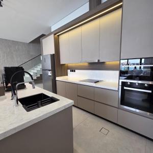 a kitchen with white cabinets and a sink at ViLora VILA in Durat Alarous