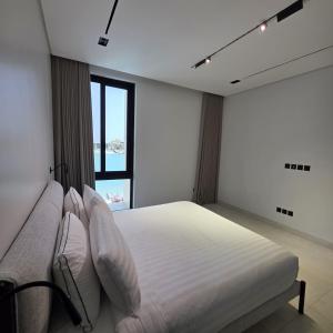a white bedroom with a bed and a large window at ViLora VILA in Durat Alarous +26 photos