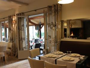 a restaurant with a table and chairs and a mirror at Logis Hôtel restaurant Horizon 117 in Sentaraille