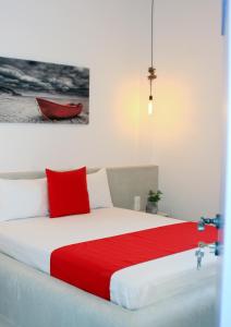 - une chambre avec un lit et une couverture rouge dans l'établissement Astropalia Luxury Studios, à Astypalée