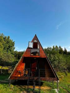 a small house with a thatched roof on a field at khedi cottage in Mestia +10 photos