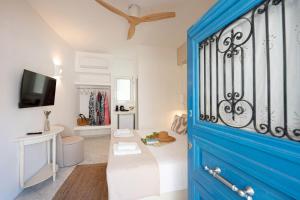 a blue door in a room with a bed at Mania Rooms and Studios in Poros