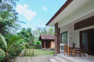 a patio of a house with a table and chairs at Tereng Wilis Jungle Inn in Tetebatu