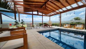 a swimming pool in a house with a roof at Posada Loma del Tigre in Los Reartes