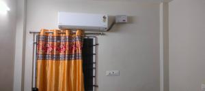 an air conditioner on a wall next to a curtain at Sri varahi rest house in Avanigadda