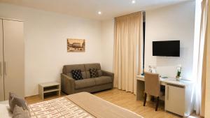 a hotel room with a bed and a desk and a couch at Real Rooms in La Spezia