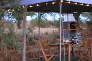 a table and chairs under a tent with a grill at Terras do Salvado Agroturismo in Fundão