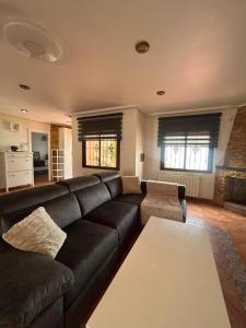 a living room with a black couch and a table at Chalet Los angeles torrevieja in Torrevieja