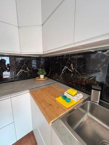 a kitchen with a sink and a wooden cutting board at Chalet Los angeles torrevieja in Torrevieja