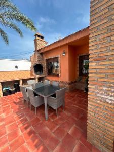 a patio with a table and chairs on a brick patio at Chalet Los angeles torrevieja in Torrevieja