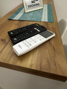 two remote controls sitting on top of a wooden table at A2 Apartment in Gostivar
