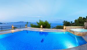 a swimming pool with a view of the water at Villa Akros and Suites in Keri