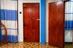 two wooden doors in a room with blue walls at RK guest in Nanu Oya