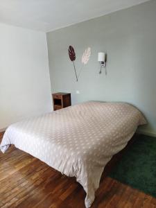 a white bed in a room with a white wall at Les lilas in Moëlan-sur-Mer +2 photos