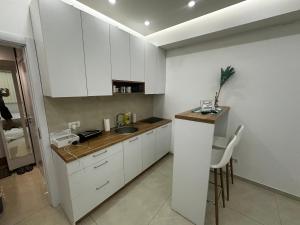 a kitchen with white cabinets and a sink and a counter at A2 Apartment in Gostivar
