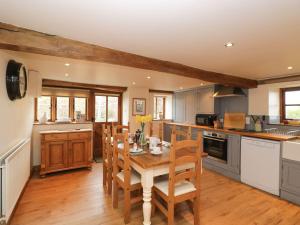 a kitchen with a wooden table and chairs in it at The Granary in Hereford