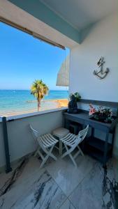 a desk and chairs in a room with a view of the beach at Miramare in Crotone