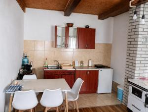 a kitchen with a table and some white chairs at Stone house in Plužine