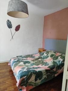 a bedroom with a bed with a colorful comforter at Les lilas in Moëlan-sur-Mer