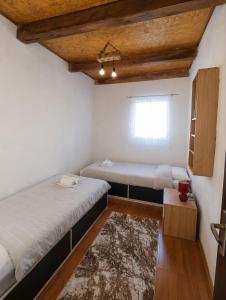 a room with two beds and a window at Stone house in Plužine