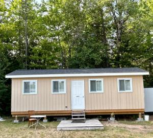 a tiny house with a door and a porch at Chicken Shack Motel in Batchawana