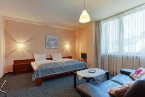 a hotel room with a bed and a couch at Central Station Hotel Dortmund in Dortmund
