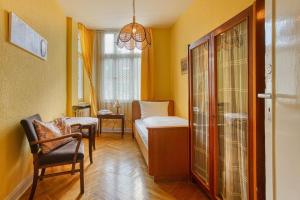 a small room with a bed and a chair and a window at Central Station Hotel Dortmund in Dortmund