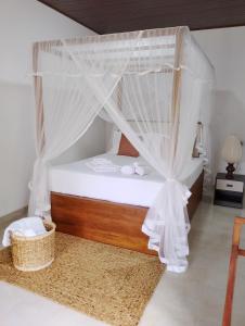 a bedroom with a bed with mosquito netting at The White Porch in Kurunegala +4 photos