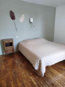 a bedroom with a bed and a night stand with a lamp at Les lilas in Moëlan-sur-Mer