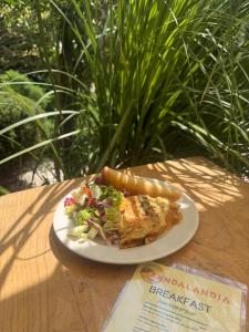 a plate of food with a sandwich and salad on a table at Camping Sandalandia in Vama Veche