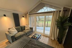 a living room with a couch and a large window at Rosetta Retreats in Peebles