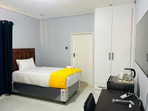 a small bedroom with a bed and a desk at Brooke Paradise in Bulawayo +59 photos