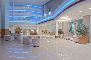 a large lobby with white chairs and a blue ceiling at LAICO Hammamet hotel in Hammamet