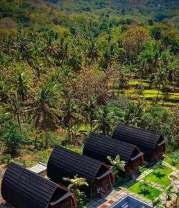 an overhead view of a group of houses with trees at The Southeast Penida in Polilit