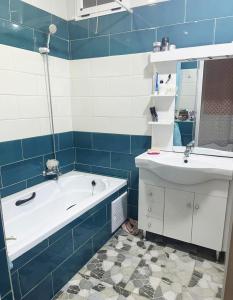 a blue and white bathroom with a tub and a sink at Apartment - Jijel in Jijel