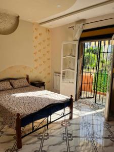 a bedroom with a bed and a large window at Apartment - Jijel in Jijel