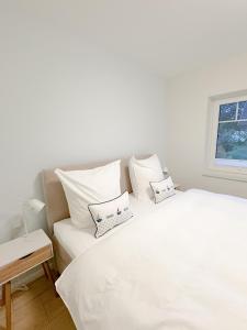 a bedroom with a white bed with two pillows on it at Ferienwohnung Knut in Lütjenbornholt