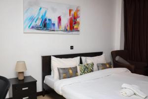a bedroom with a bed and a picture on the wall at Premier Place, Sky Suites in Accra